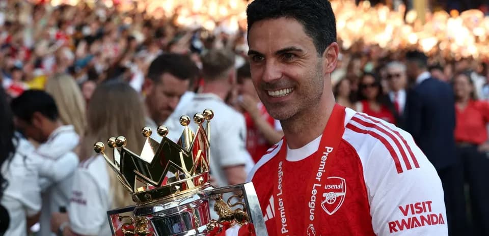Entrenador de Arsenal sosteniendo el trofeo de Premier League