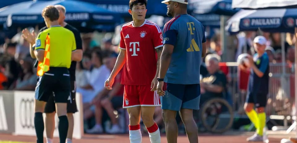 Jugador de Bayern Munich conversando con entrenador en la línea de banda