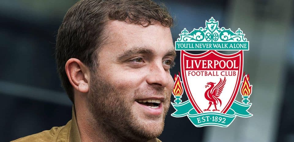 Persona sonriendo junto al escudo del Liverpool FC