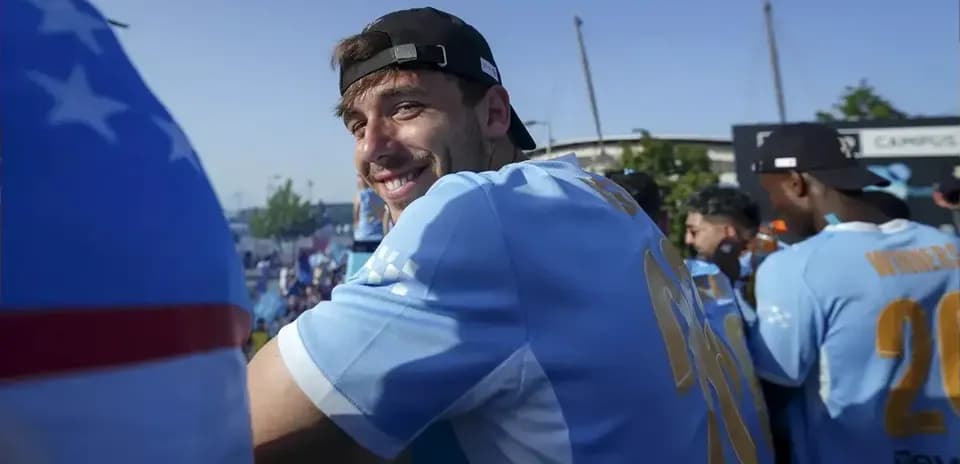Jugador sonriendo en celebración con otros compañeros
