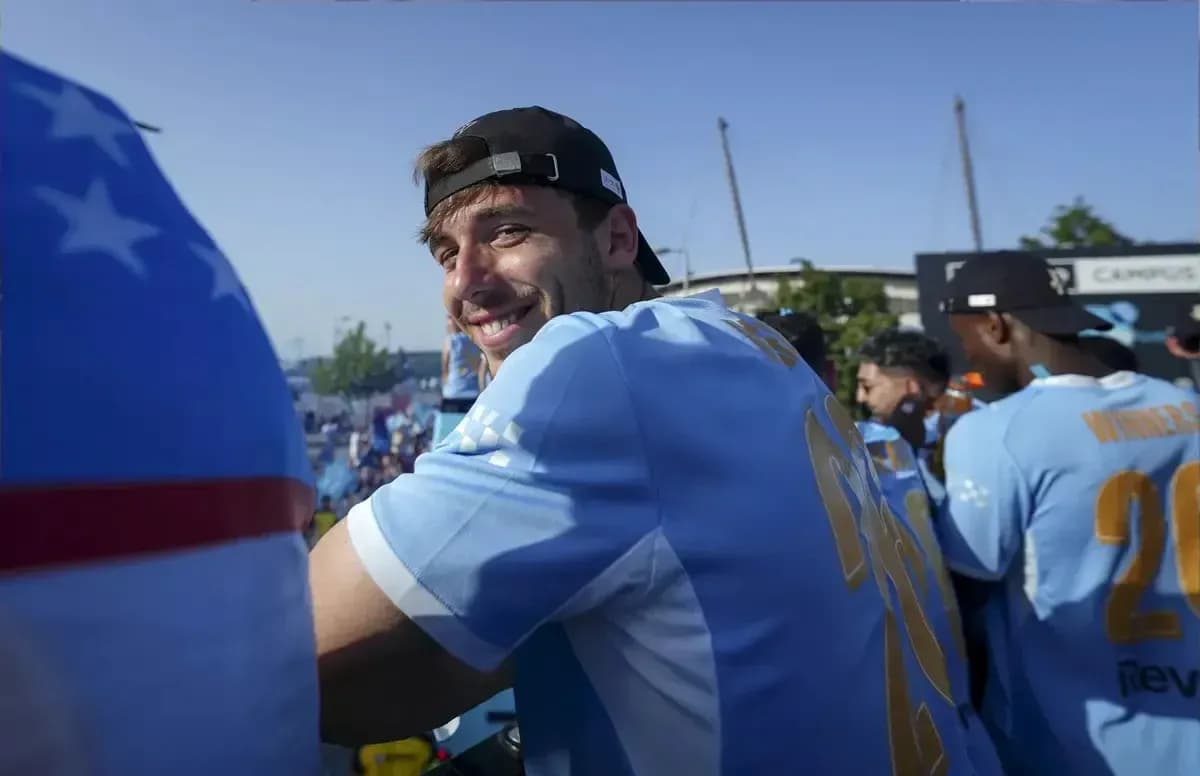 Jugador sonriendo en celebración con otros compañeros