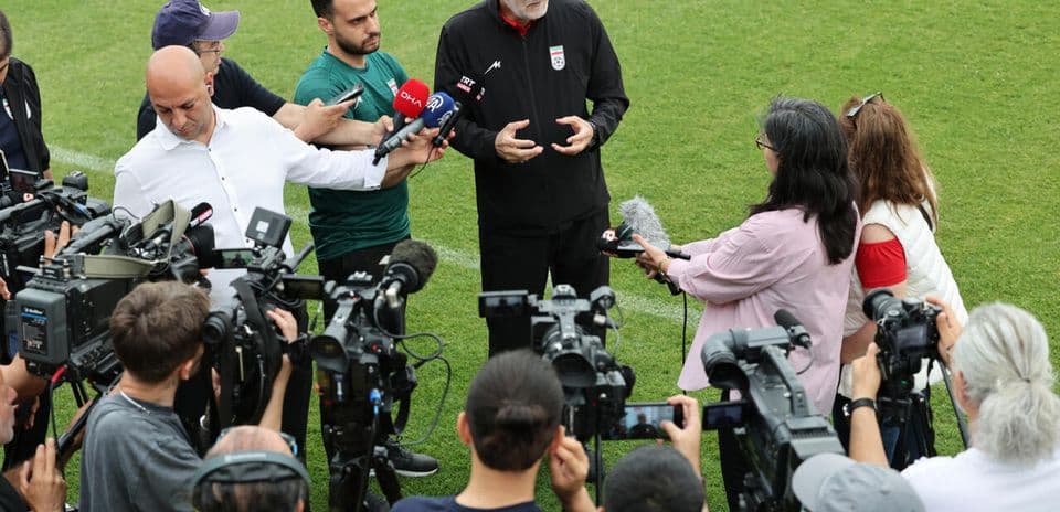 Entrenador siendo entrevistado por periodistas en el campo