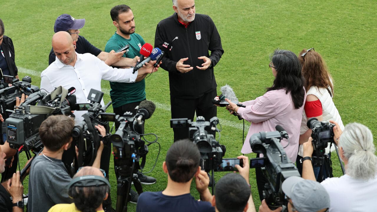 Entrenador siendo entrevistado por periodistas en el campo