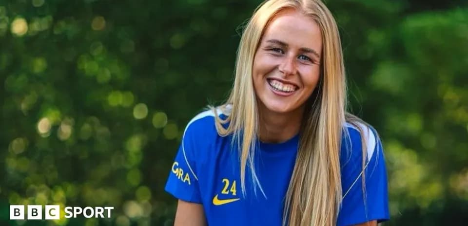 Jugadora sonriente con camiseta azul en fondo verde