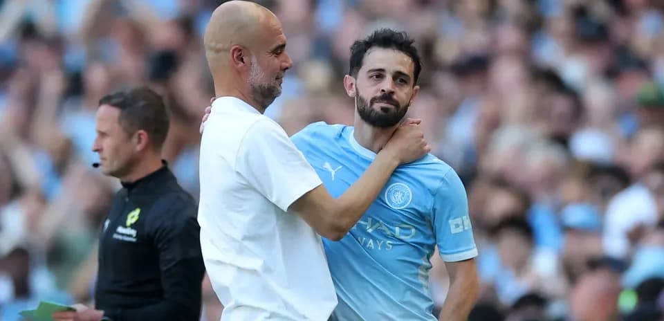 Pep Guardiola abrazando a Bernardo Silva en el campo