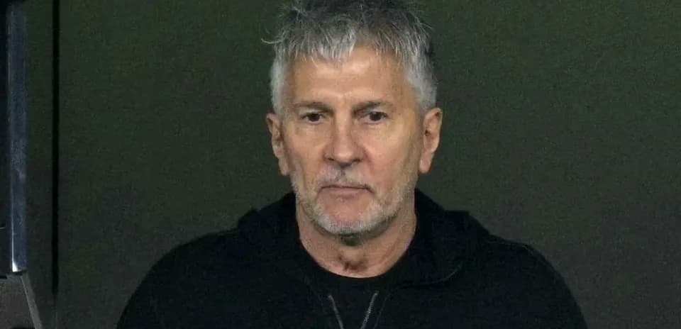 Hombre con cabello gris en un fondo oscuro