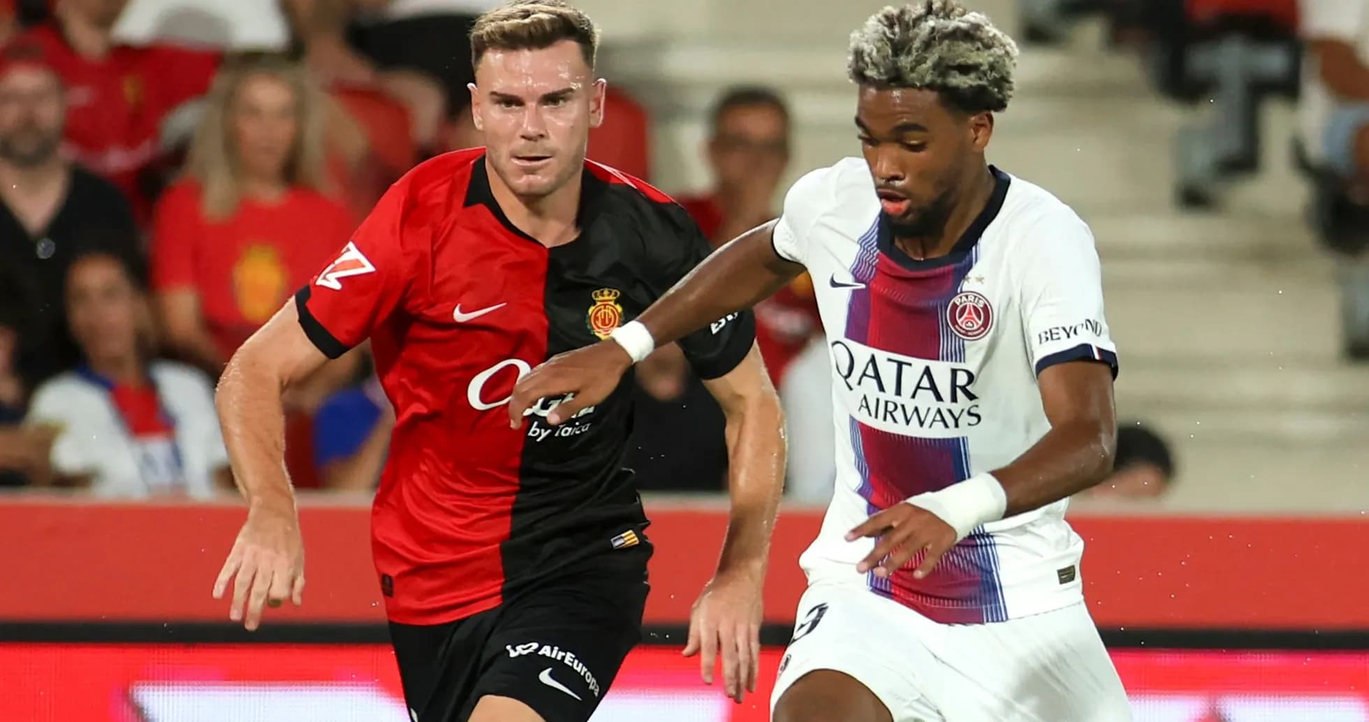 Jugadores de Mallorca y PSG compitiendo por el balón