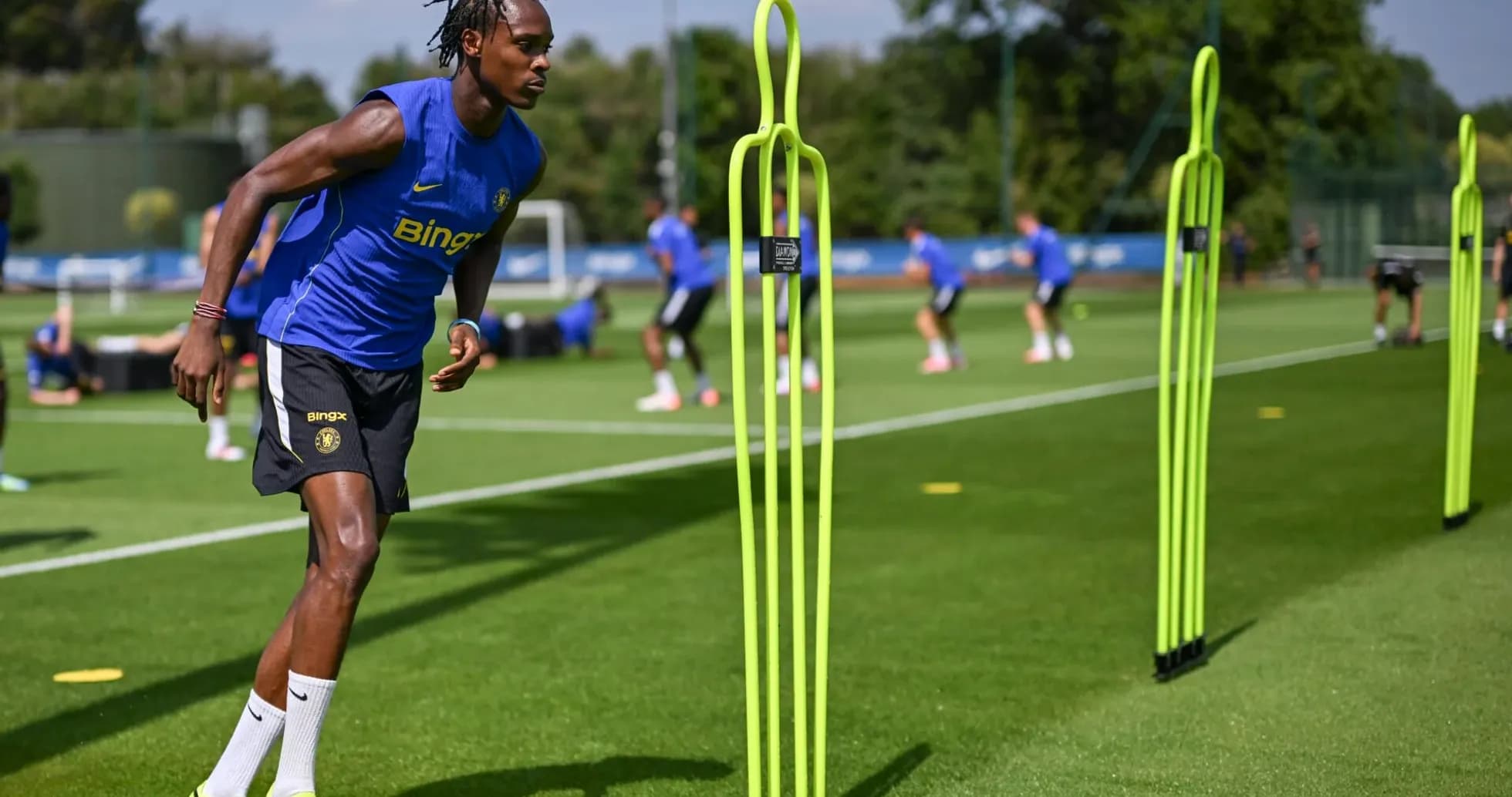 Jugador entrenando en campo con conos de agilidad