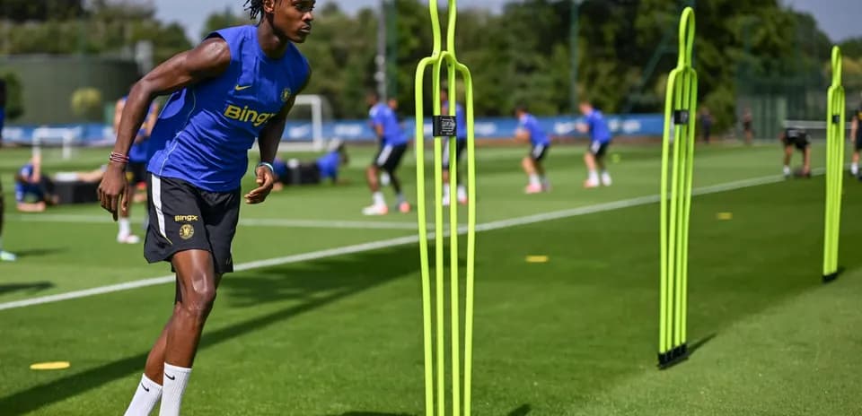 Jugador entrenando en campo con conos de agilidad