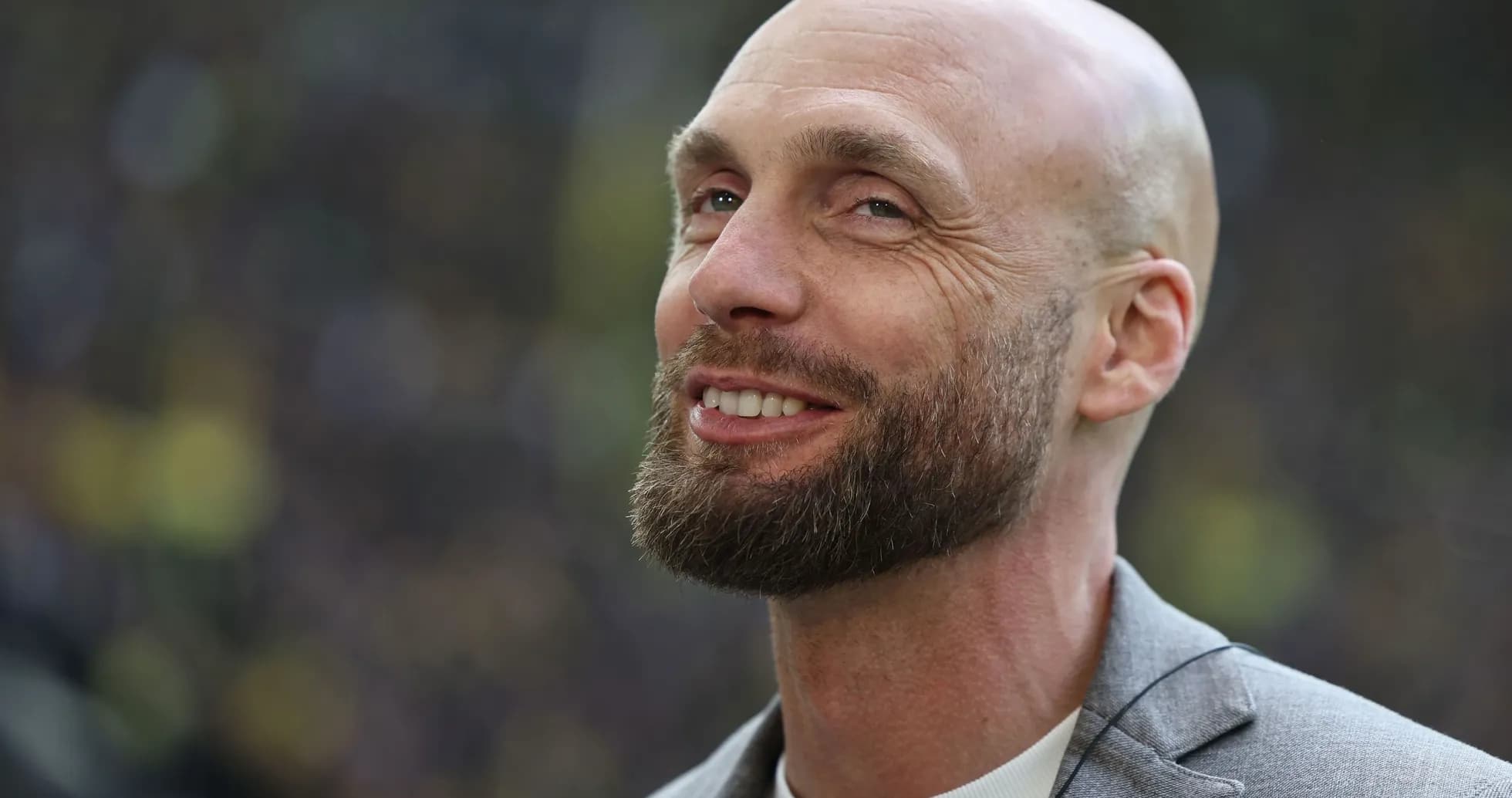 Hombre con barba sonriendo en un evento deportivo