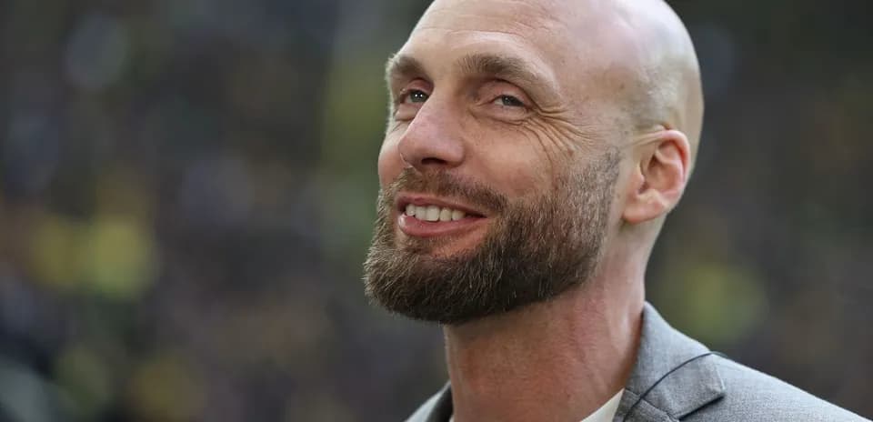 Hombre con barba sonriendo en un evento deportivo