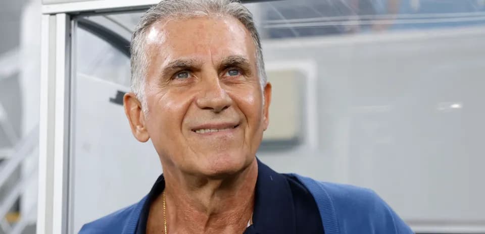 Entrenador sonriendo en el banquillo del estadio