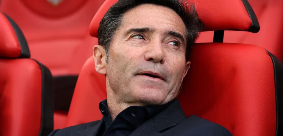 Entrenador sentado en banquillo con fondo rojo