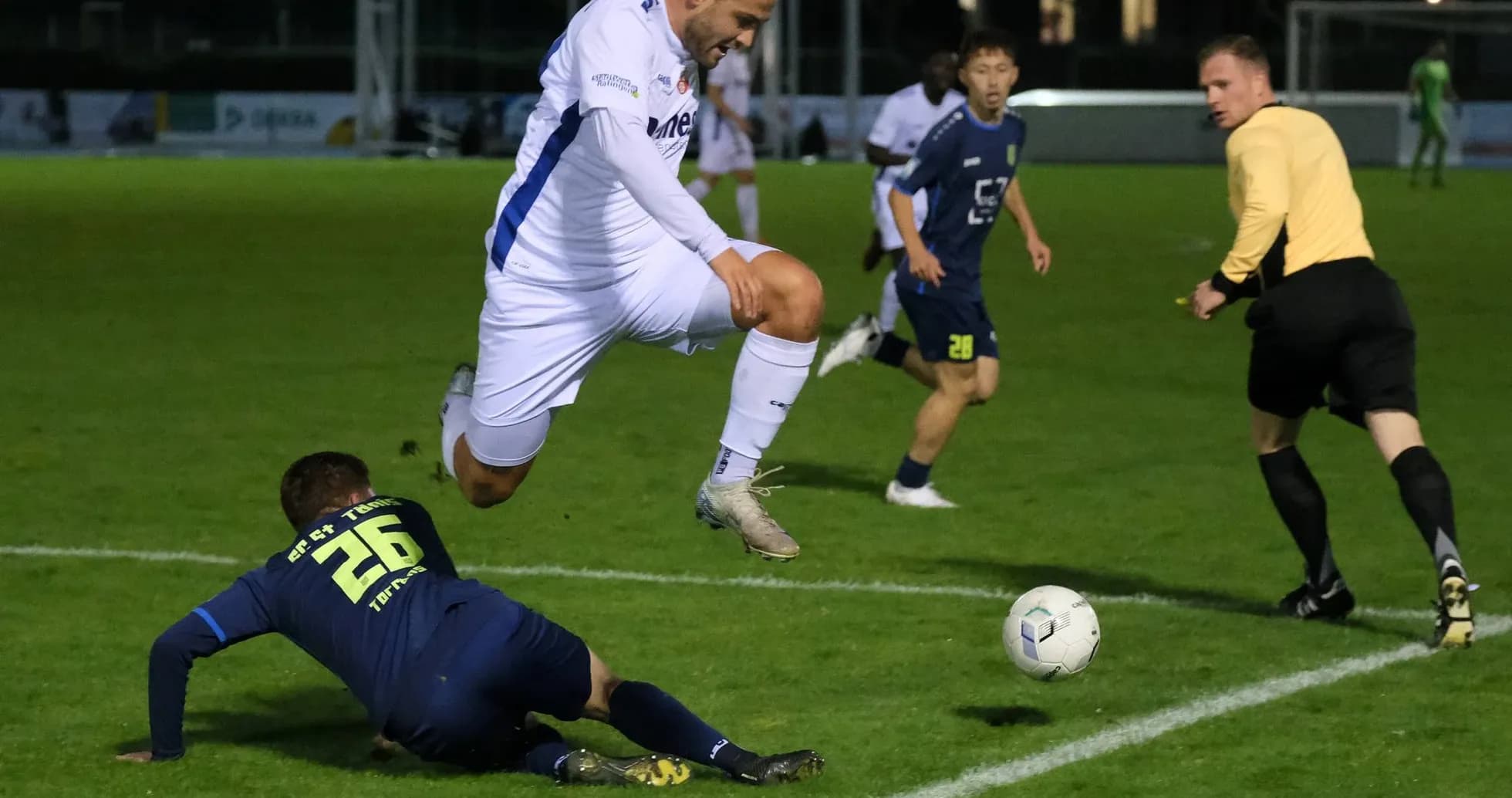 Jugador saltando sobre oponente en el campo
