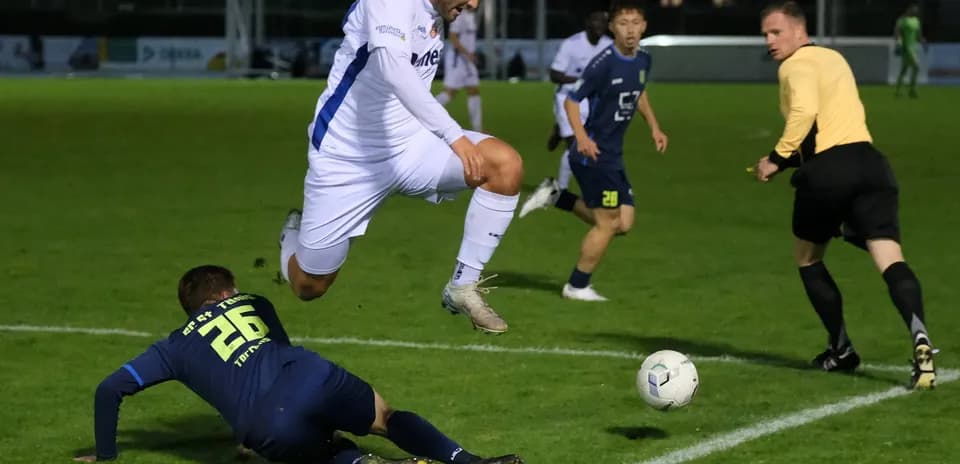 Jugador saltando sobre oponente en el campo