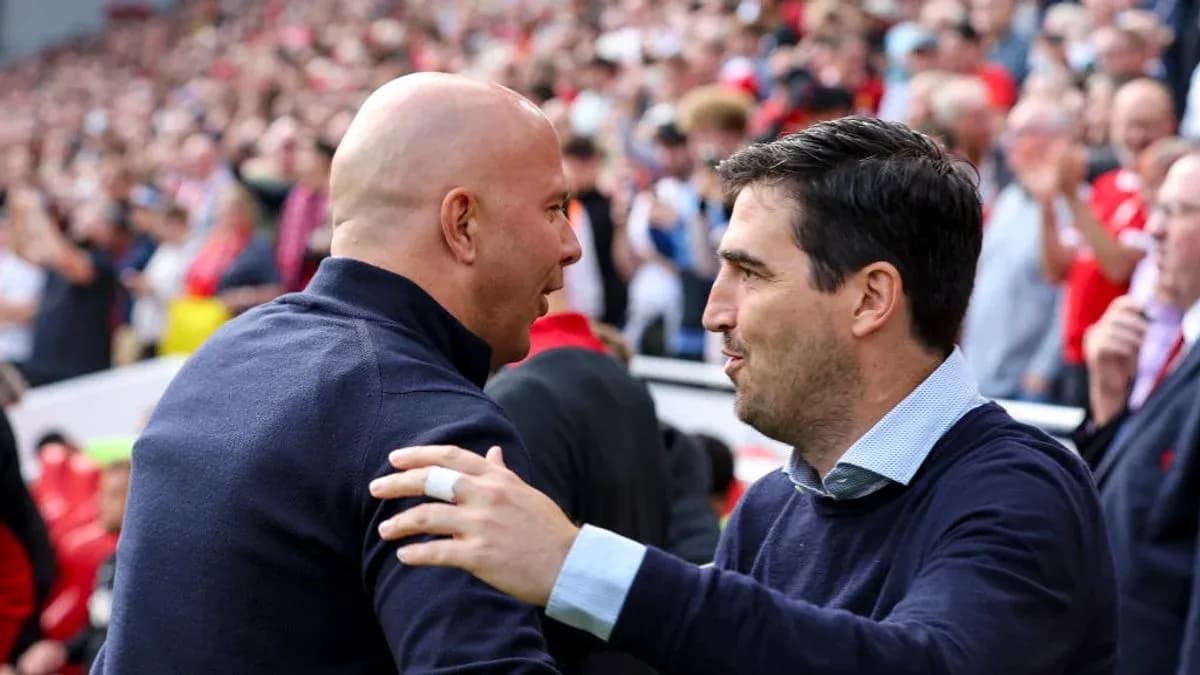 Entrenadores saludándose en el estadio lleno de aficionados