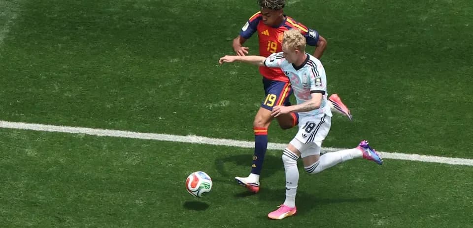 Jugador de Alemania disputando el balón con jugador de España