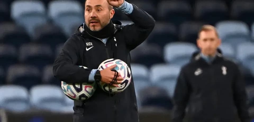 Entrenador sosteniendo balones y dando instrucciones