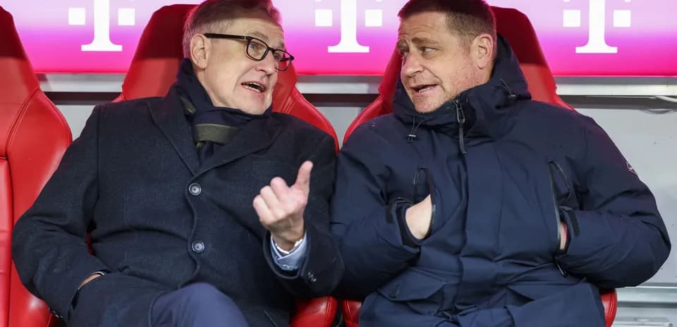 Dos personas conversando en el banquillo del estadio