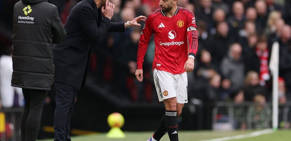 Entrenador instruyendo a jugador de Manchester United