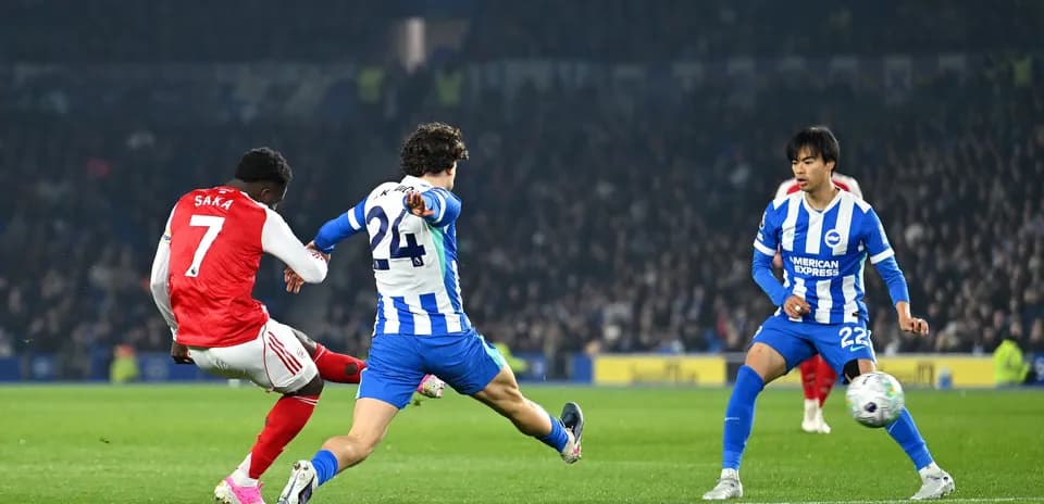 Saka disparando mientras es defendido por Brighton