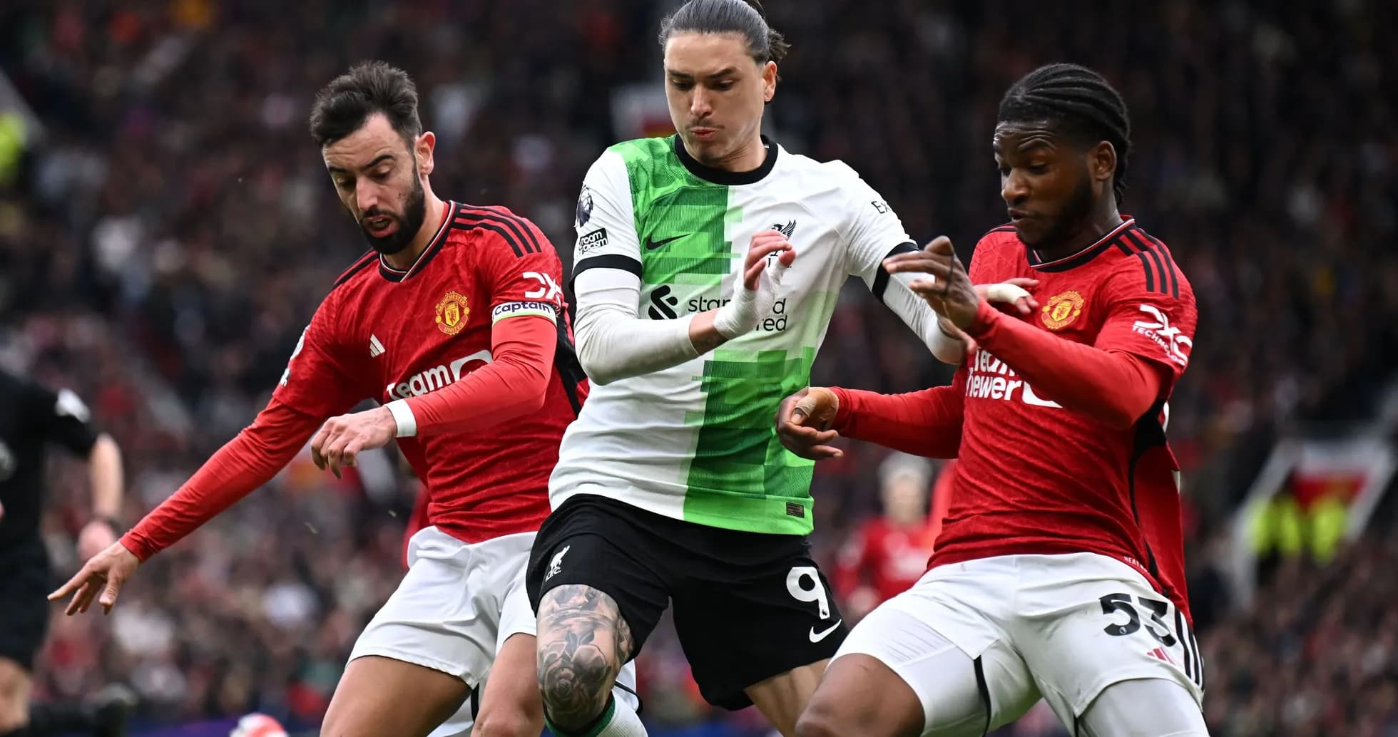 Jugadores de Liverpool y Manchester United luchando por el balón