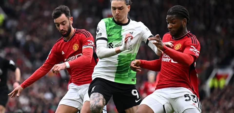 Jugadores de Liverpool y Manchester United luchando por el balón