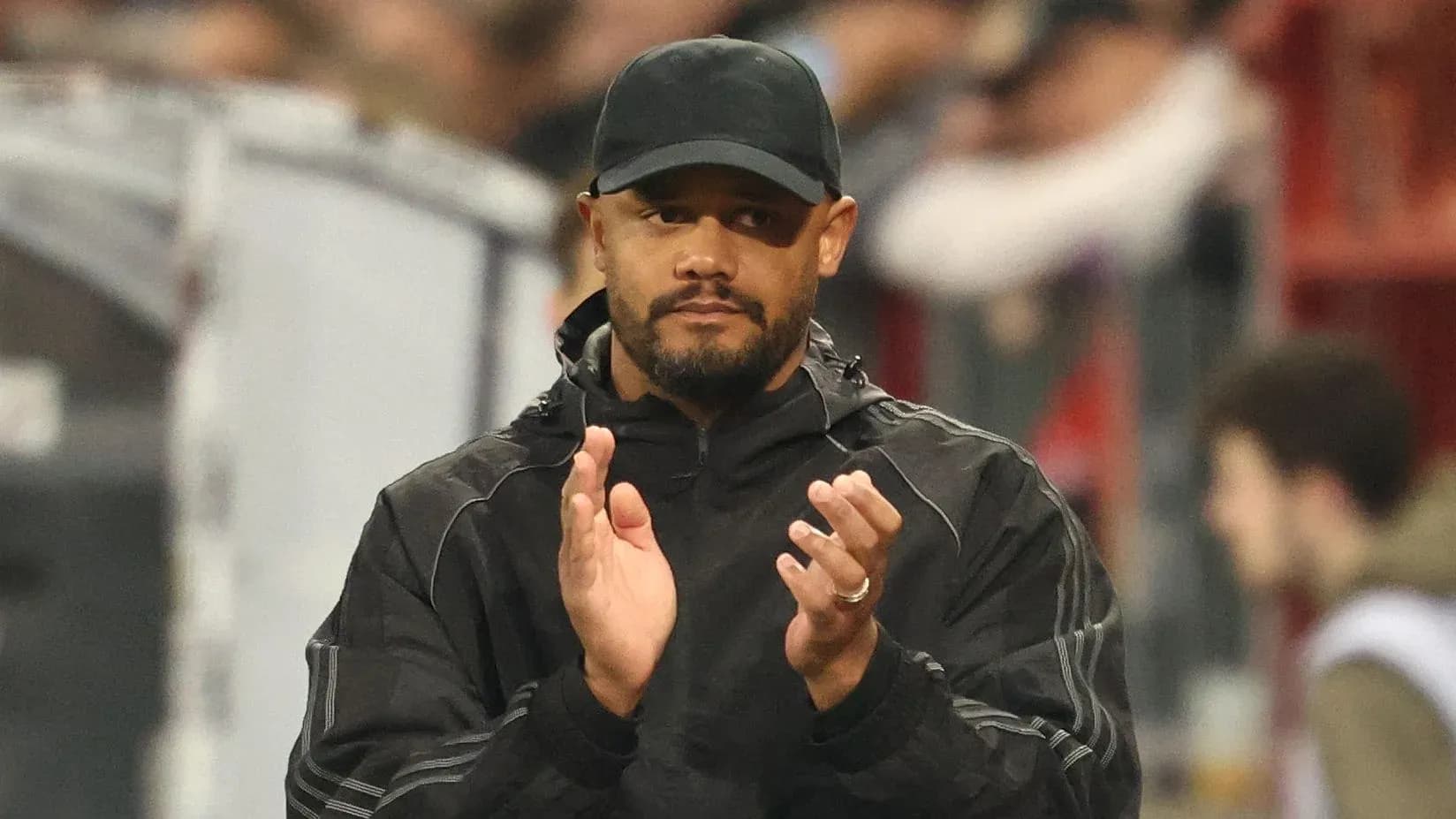 Entrenador aplaudiendo en la banda del estadio