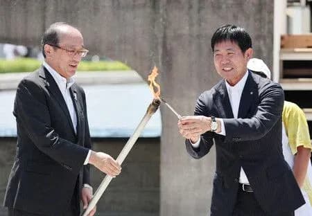 Dos personas encendiendo una antorcha en evento