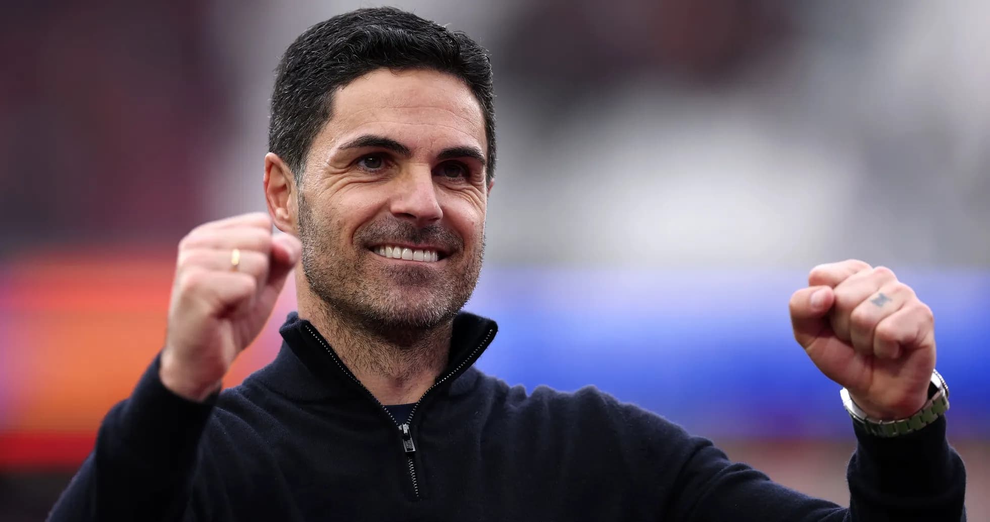 Entrenador celebrando con puños cerrados en el estadio