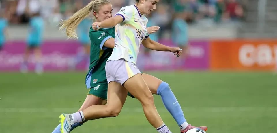 Jugadora de Orlando Pride driblando a rival de Bay FC
