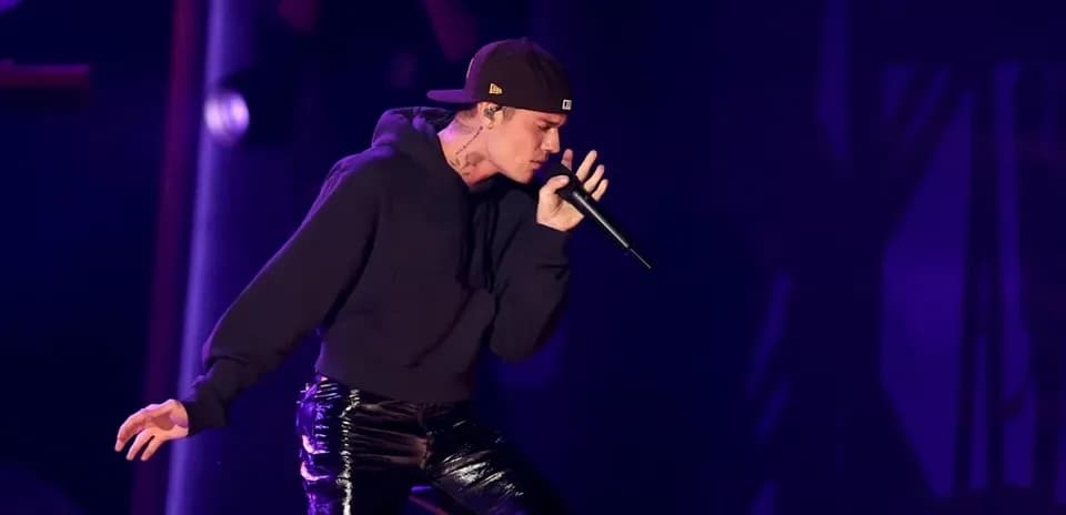 Artista cantando con micrófono en el escenario