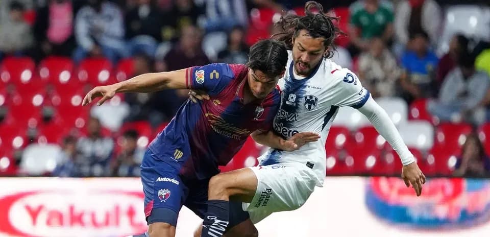 Dos jugadores compitiendo por el balón en Liga MX