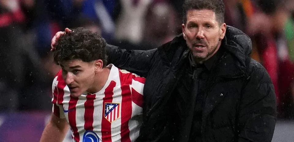 Entrenador ayudando a jugador de Atlético de Madrid