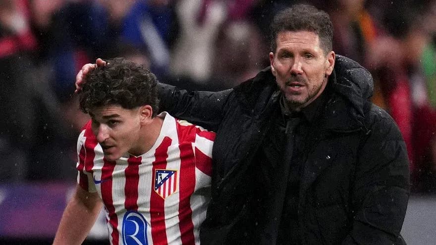 Entrenador ayudando a jugador de Atlético de Madrid