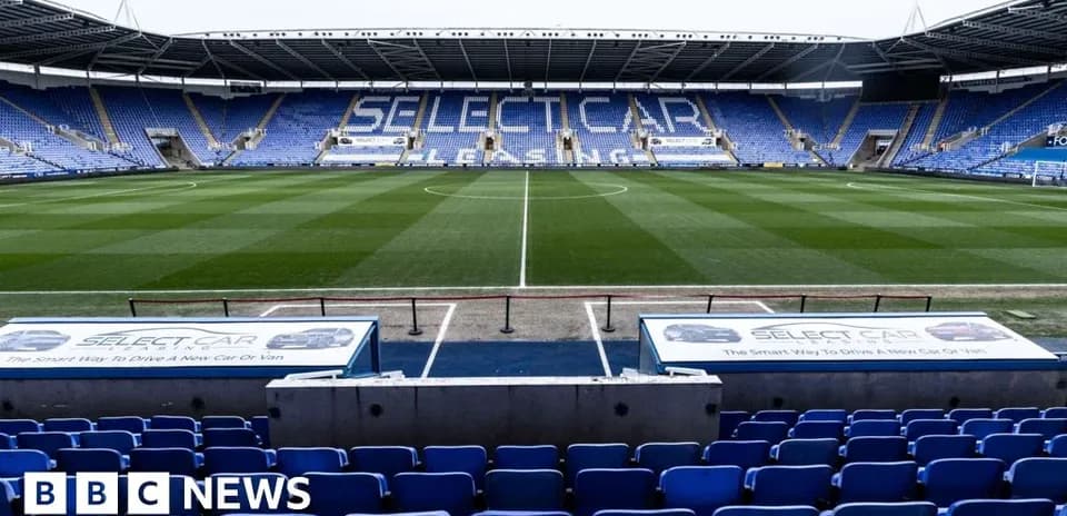 Estadio vacío con asientos azules y césped