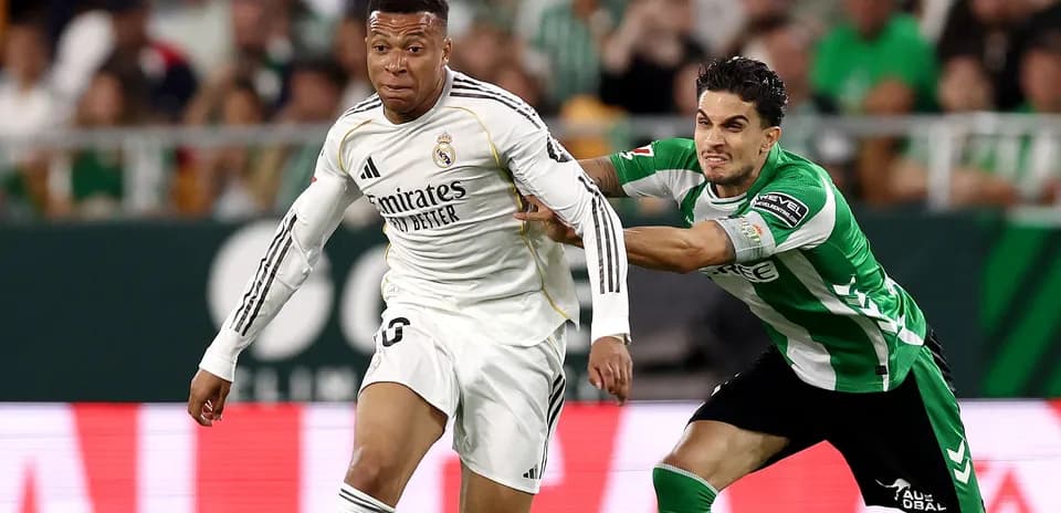 Jugador de Real Madrid siendo marcado por rival