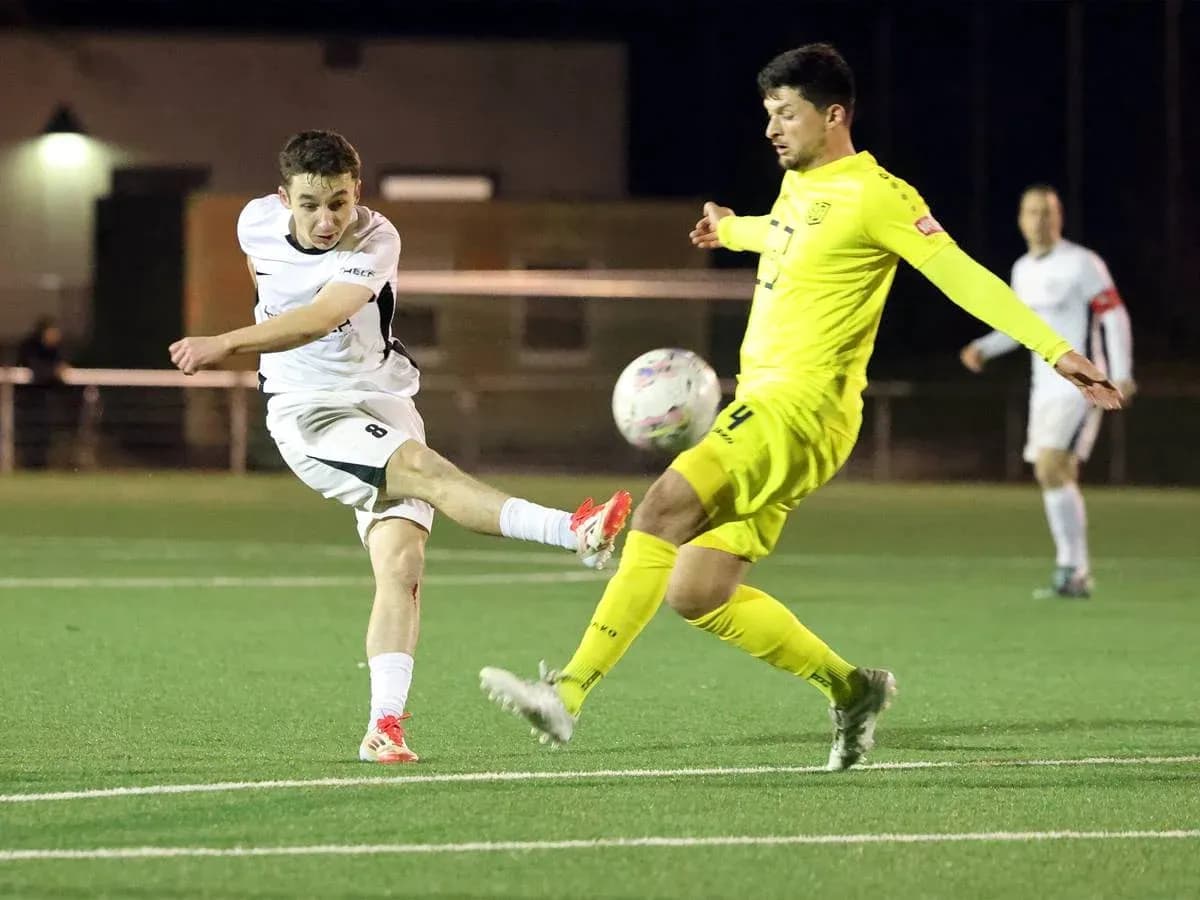 Jugador dispara a puerta en partido de fútbol