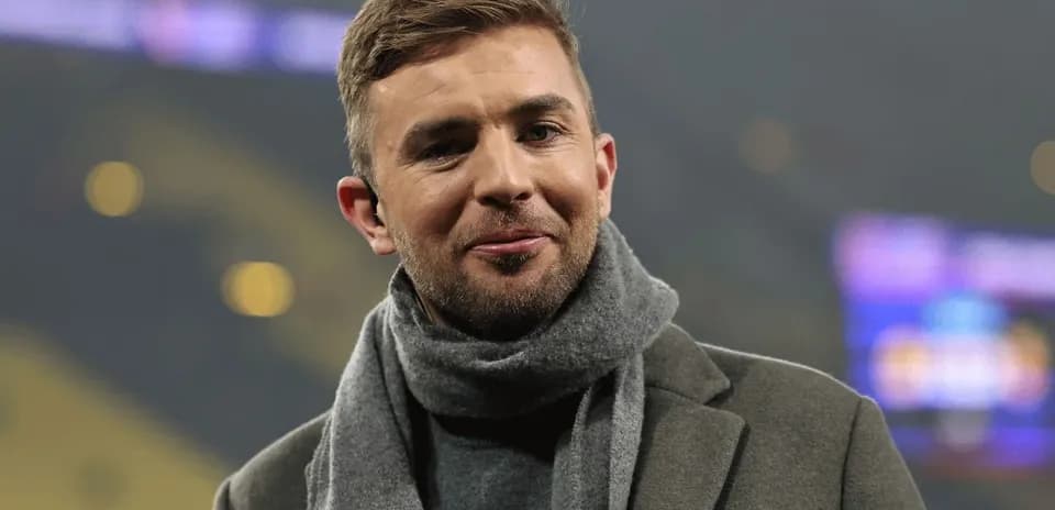 Hombre con abrigo y bufanda en un estadio