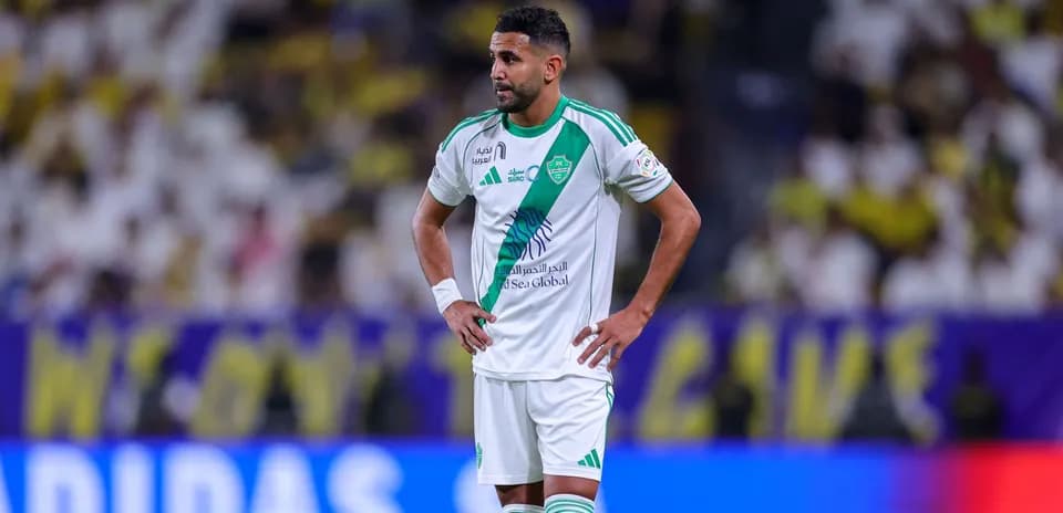 Jugador de fútbol en campo con uniforme blanco y verde