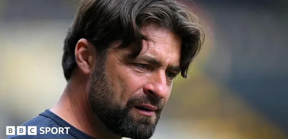 Entrenador observando durante un partido en el estadio