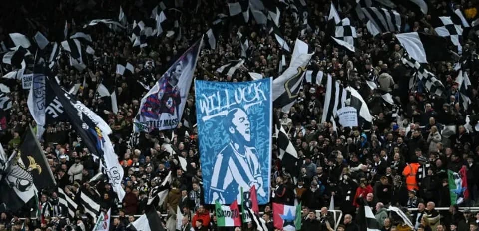 Aficionados con banderas en un estadio lleno