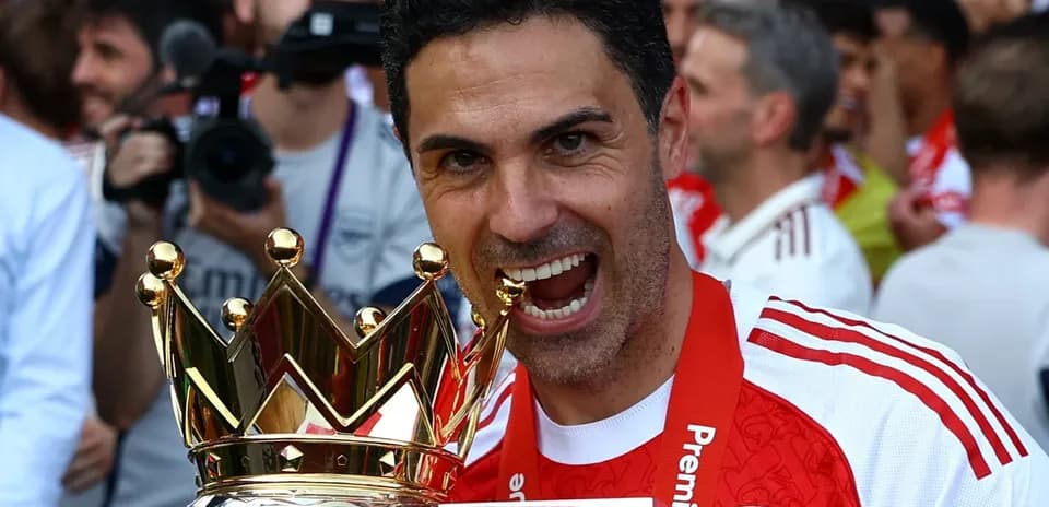 Entrenador de Arsenal sosteniendo trofeo de Premier League