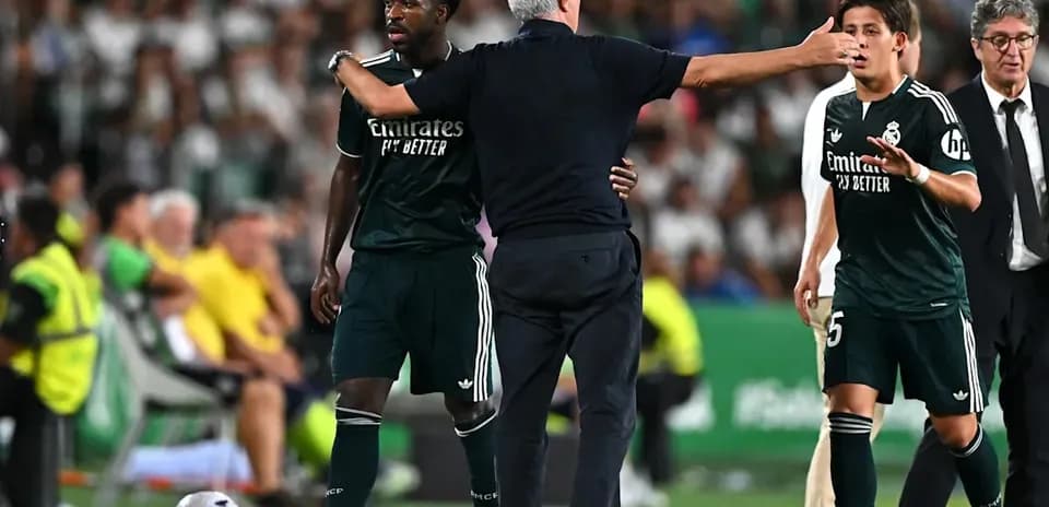 Entrenador dando instrucciones a jugadores en el banquillo