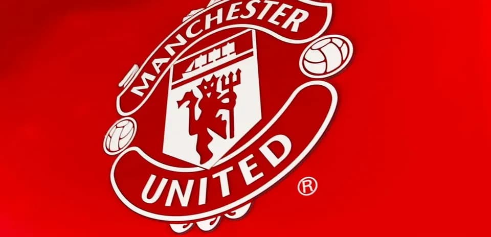 Escudo de Manchester United sobre fondo rojo
