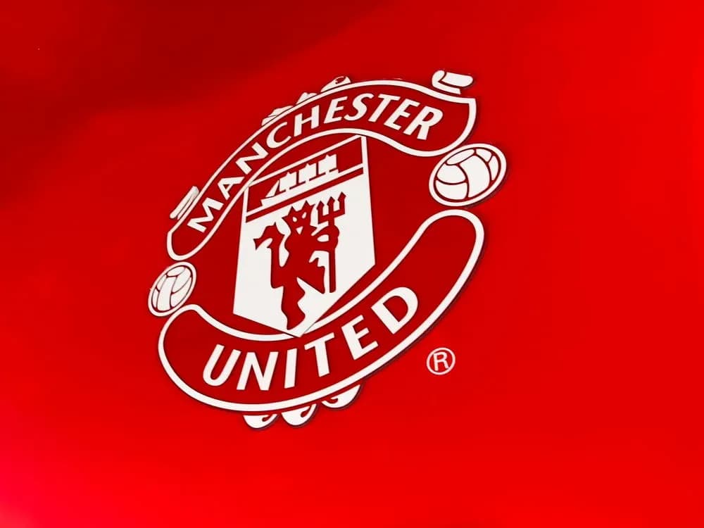 Escudo de Manchester United sobre fondo rojo