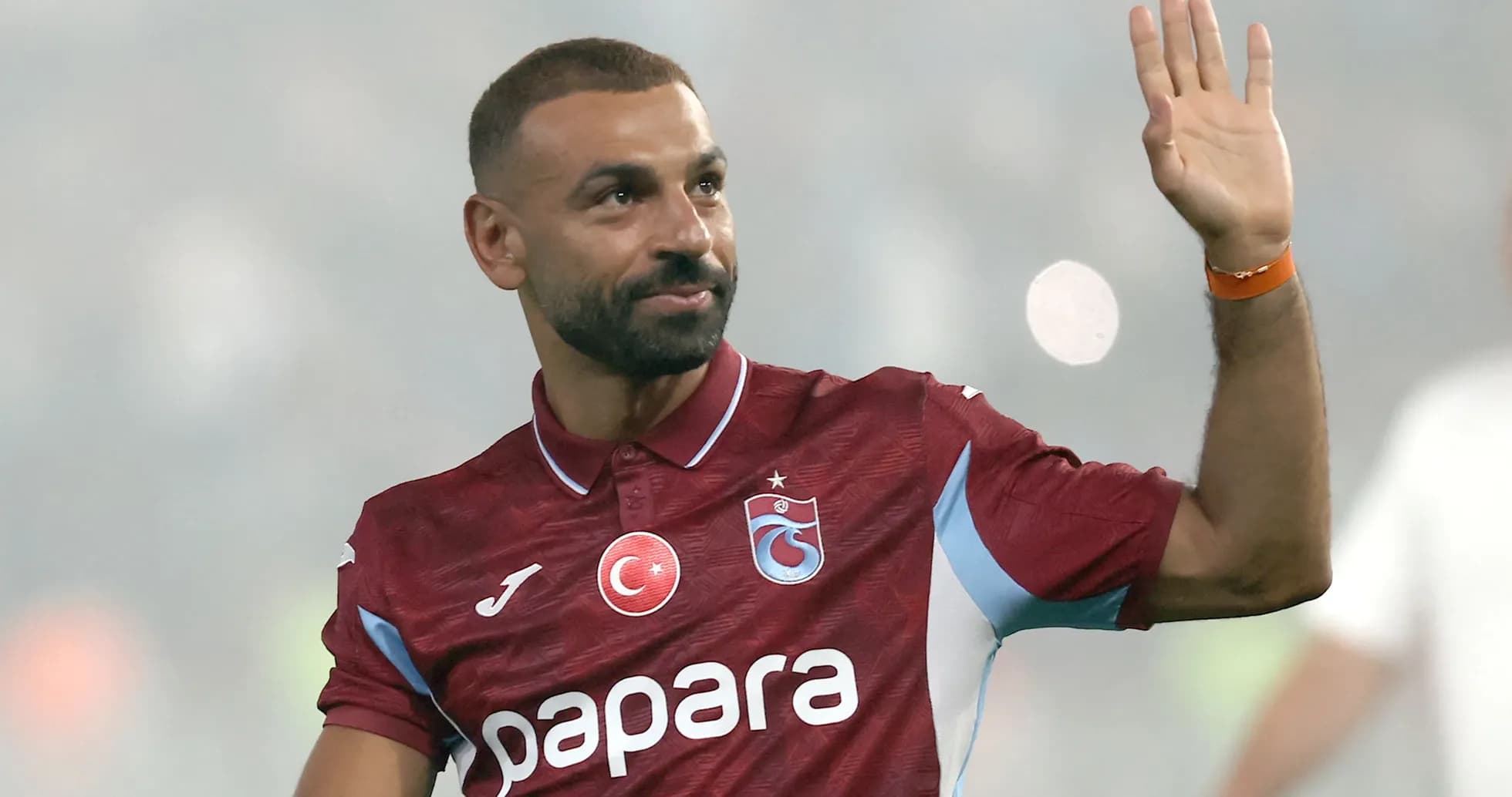 Jugador saludando durante un partido de fútbol