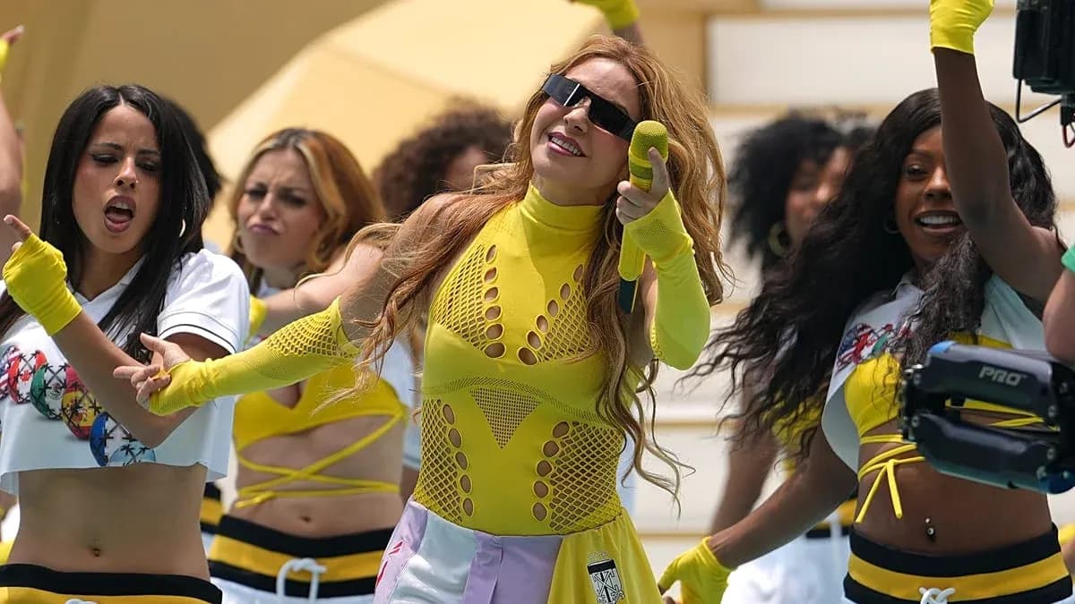 Artista principal actuando con bailarinas en escenario