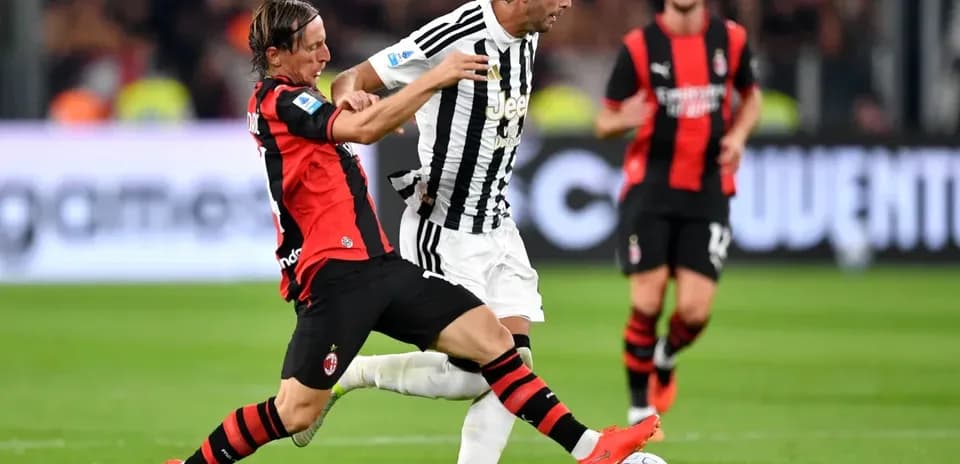 Jugador de AC Milan disputa el balón con jugador de Juventus