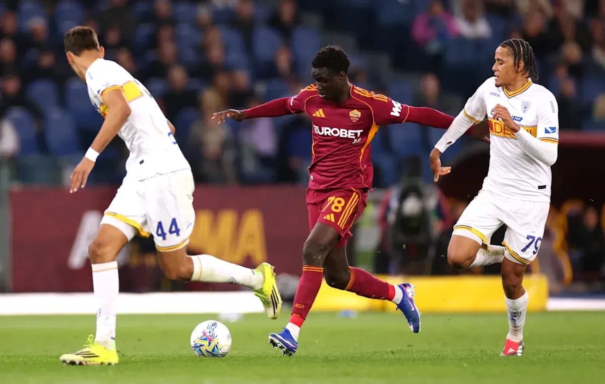Jugador de la Roma driblando entre dos oponentes